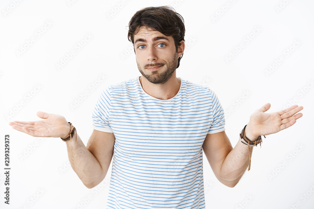 Nothing you can do. Portrait of uninvolved careless handsome guy swipe hands sideways pursing lips and shrugging as being questioned and uninterested, smirking with sorry look over white wall Nothing you can do. Portrait of uninvolved careless handsome guy swipe hands sideways pursing lips and shrugging as being questioned and uninterested, smirking with sorry look over white wall