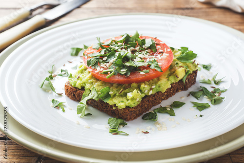 Avocado toast. Healthy toast with avocado mash and tomatoes on a plate.