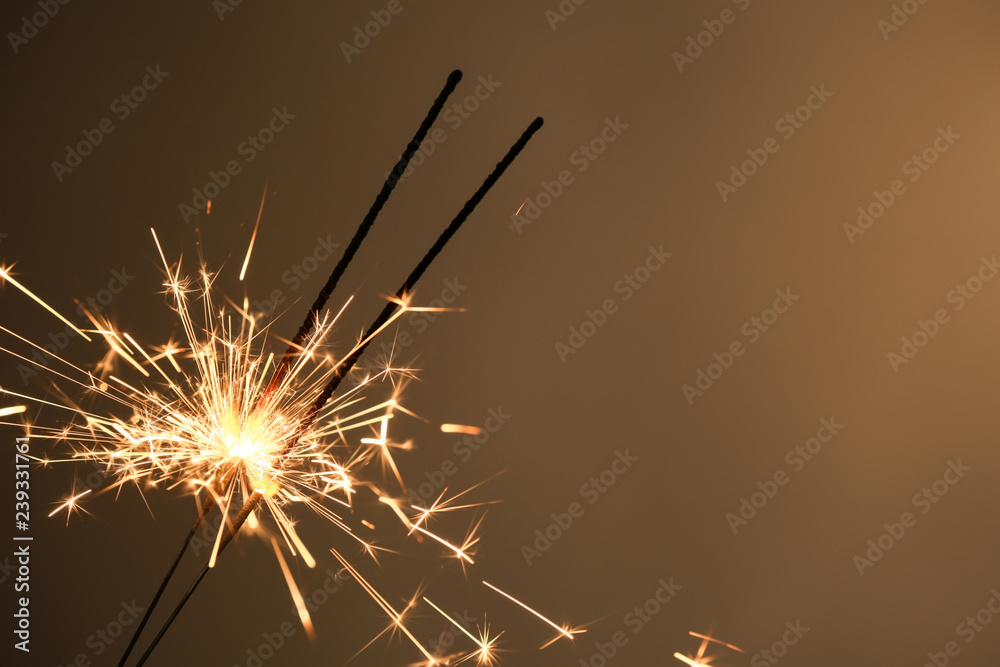 Fototapeta premium Festive Christmas sparklers on color background
