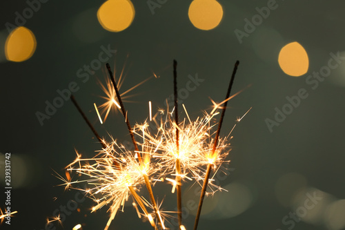 Fototapeta Naklejka Na Ścianę i Meble -  Festive Christmas sparklers on dark background