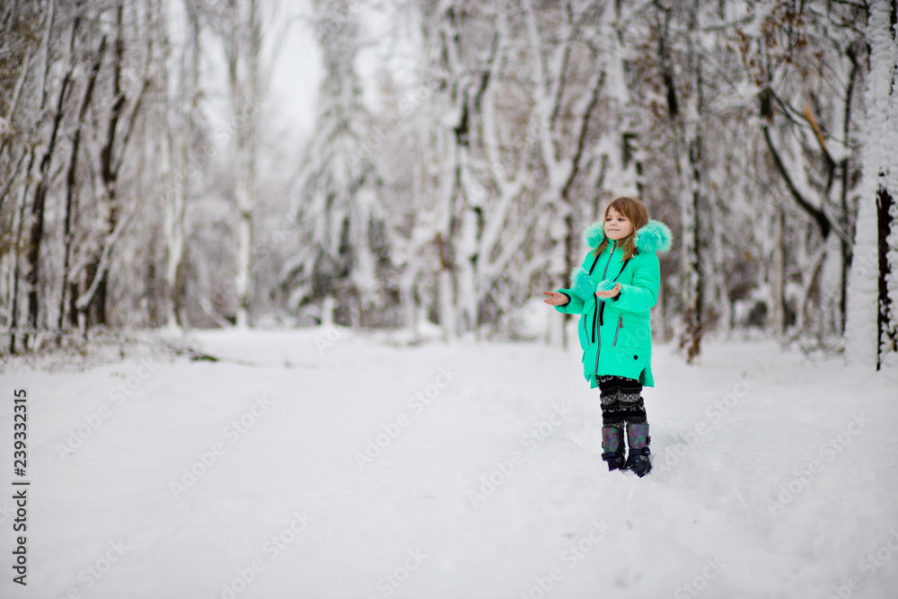 Funny little girl having fun in beautiful park during snowfall Funny little girl having fun in beautiful park during snowfall