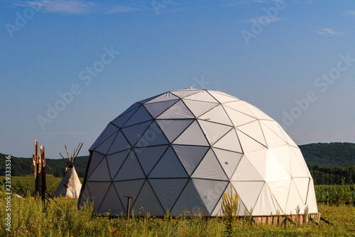 white geodesic dome on a sunny summer day in nature