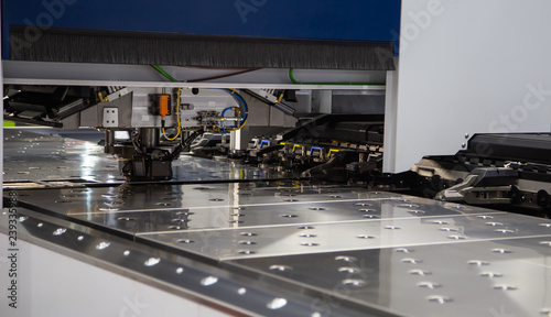 Laser cutting machine cutting metal sheet in industrial factory