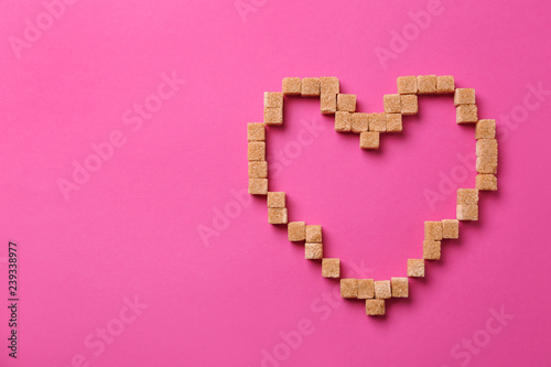 Heart made of sugar on color background