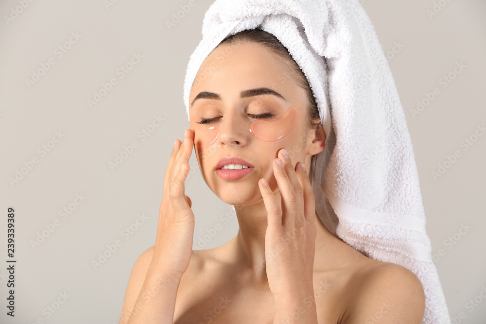 Beautiful young woman with under-eye patches on light background Beautiful young woman with under-eye patches on light background