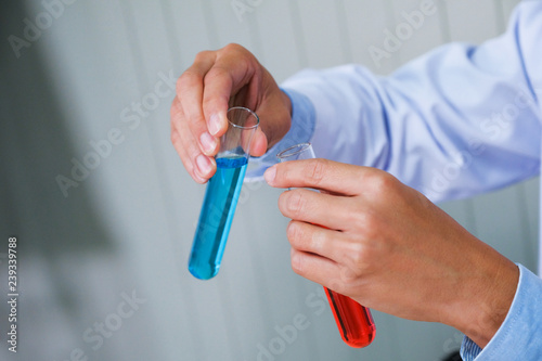 Male scientist standing with techer in lab worker making medical research in modern laboratory. Scientist holding documents folder with analysis results.