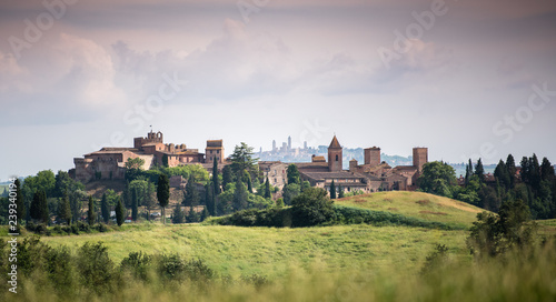 Scenic panorama of medieval village of Certaldo old town  Italy  with San Gimignano towers in the background  typical Italian and Tuscany countryside landscape