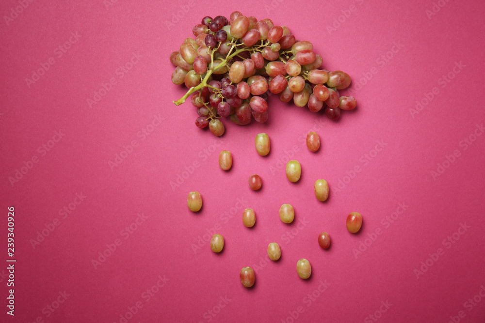 Creative composition with tasty grapes on color background