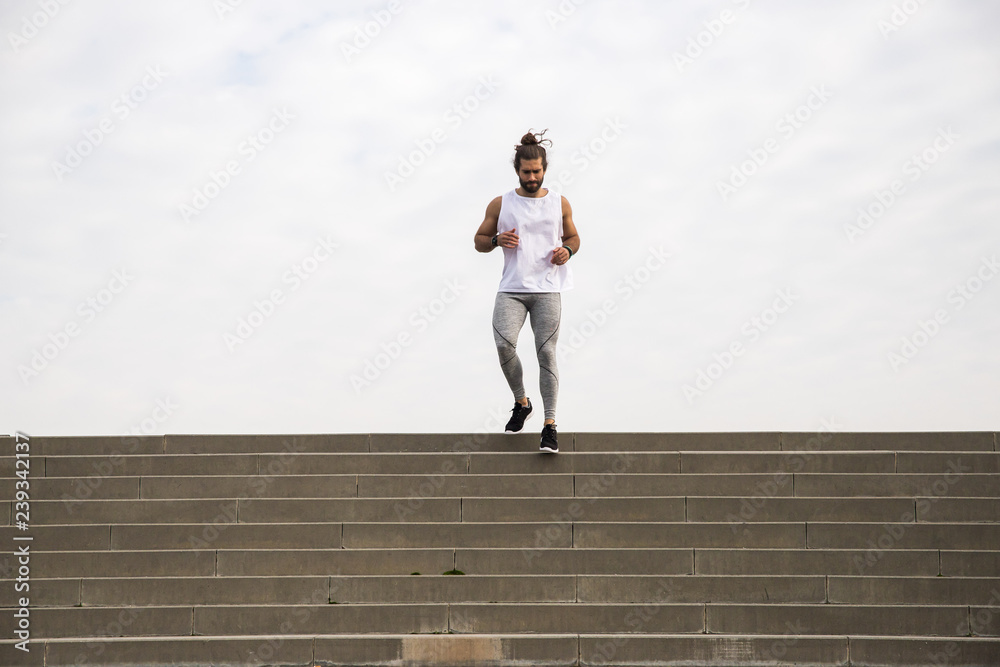 young man with long hair wearing sport wear going up and down the stairs young man with long hair wearing sport wear going up and down the stairs