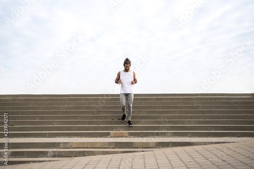young man with long hair wearing sport wear going up and down the stairs