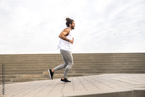 young man with long hair wearing sport wear running