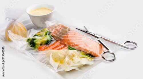 Salmon cooked sous vide with vegetables on a white background