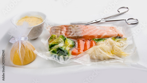 Salmon cooked sous vide with vegetables on a white background photo