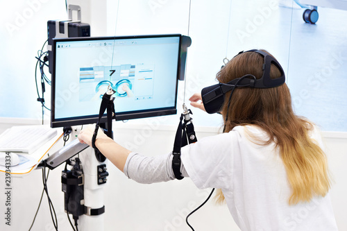 Woman on stand with virtual reality device for rehabilitation