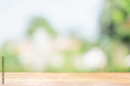 Empty of wood table top on blur of window view green from tree garden background.For montage product display or design key visual layout