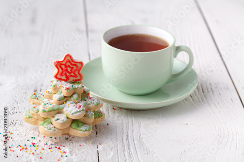 Christmas butter cookies with festive decoration on white wooden background