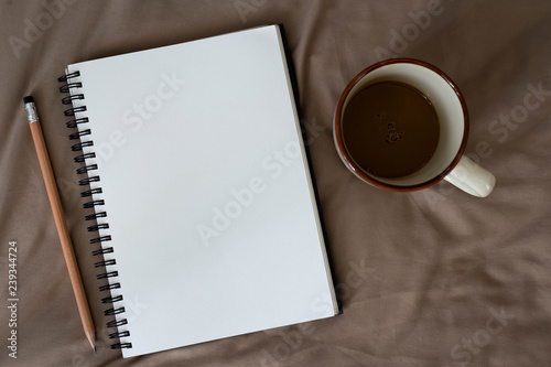 Top view of Note Book with Coffee on bed,