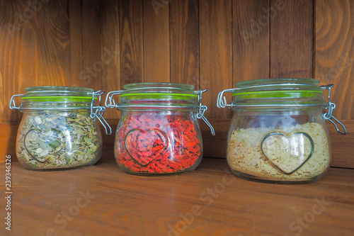 Pumpkin seeds, dried goji berries and yeast flakes in jars on an old cupboard
