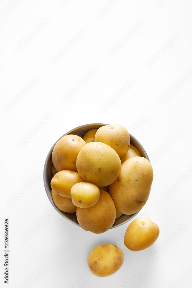 Fresh potatoes pile in a bowl isolated on a white background viewed from above. Top view. Copy space Fresh potatoes pile in a bowl isolated on a white background viewed from above. Top view. Copy space