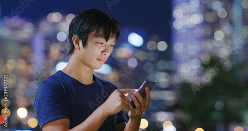 Man use of cellphone in city at night
