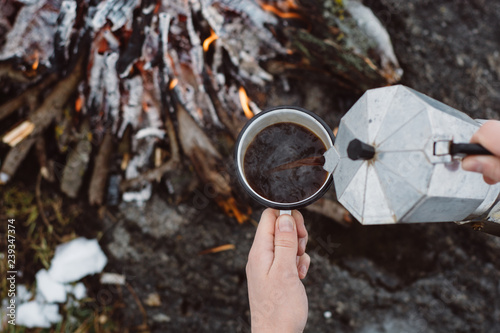 Wallpaper Mural Traveling-woman  a  sits near camp fire an in winter time and pours itself hot coffee . Concept adventure active vacations outdoor. Winter camping Torontodigital.ca