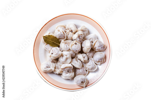Homemade meat dumplings. Russian pelmeni with laurel leaf on plate isolated on white background. Top view.