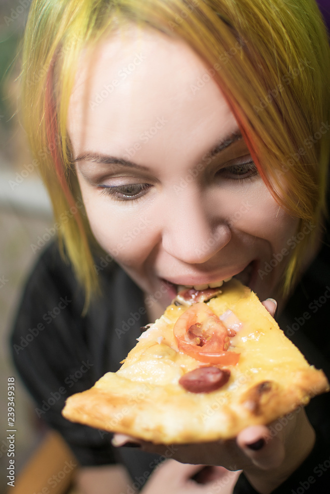 Shocked woman with mad eyes bites pizza. Shocked woman with mad eyes bites pizza.