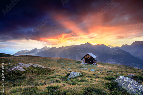 Wooden hut framed by fiery sky and clouds at sunset Muottas Muragl St.Moritz Engadine Canton of Graub√ºnden Switzerland Europe