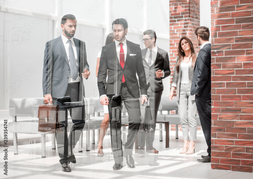 group of business people passing through the lobby of the business center group of business people passing through the lobby of the business center