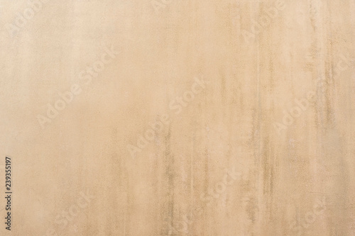 Beige painted wall of an old house with worn plaster and concrete manifestation. Background