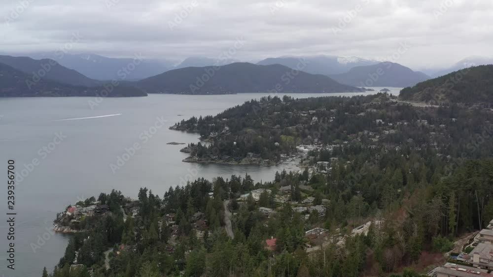 Aerial view over Burrard Inlet, ocean and island with boat and mountains in beautiful British Columbia. Canada. Aerial view over Burrard Inlet, ocean and island with boat and mountains in beautiful British Columbia. Canada.
