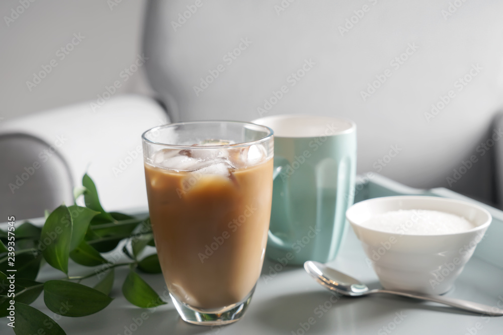 Glass of tasty frappe coffee and bowl with sugar on table Glass of tasty frappe coffee and bowl with sugar on table