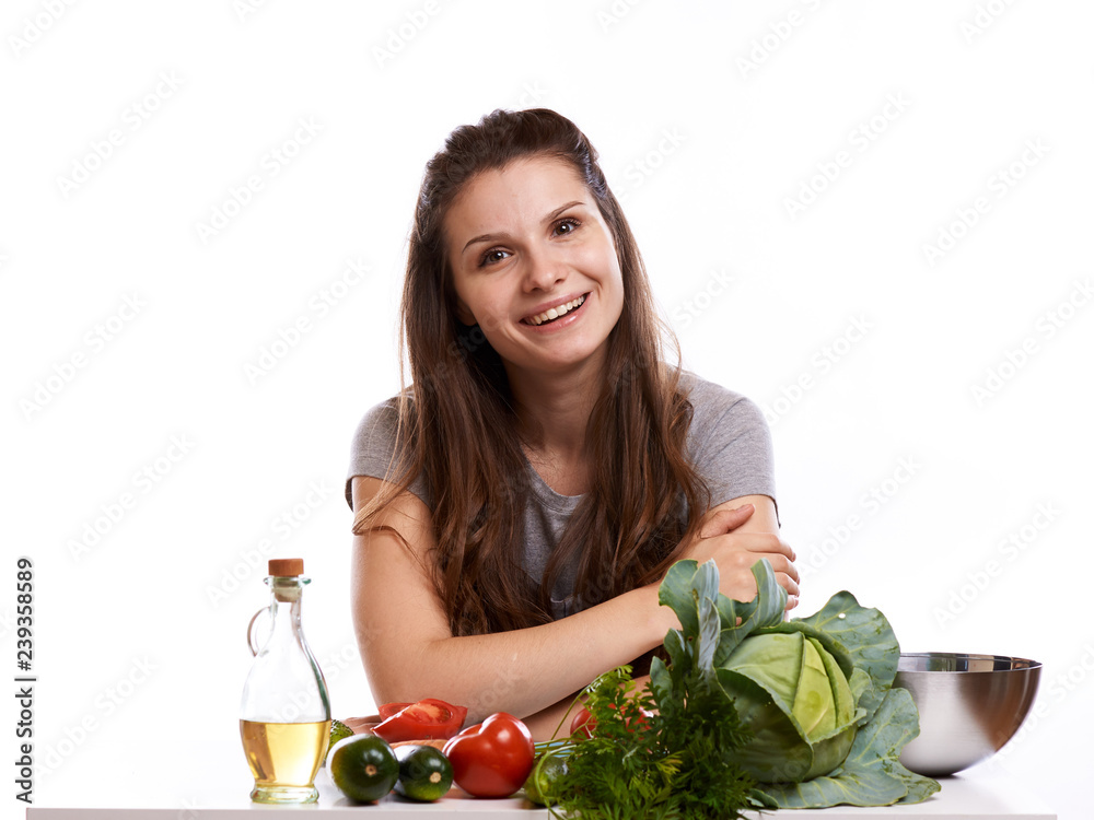 happy adult woman with various fresh vegetables on kitchen table looking at camera happy adult woman with various fresh vegetables on kitchen table looking at camera
