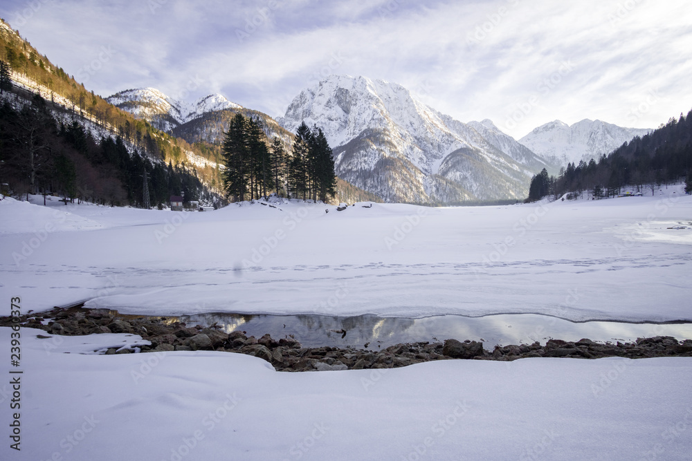 Photo of mountain in the back and frozen Predil lake in the front
