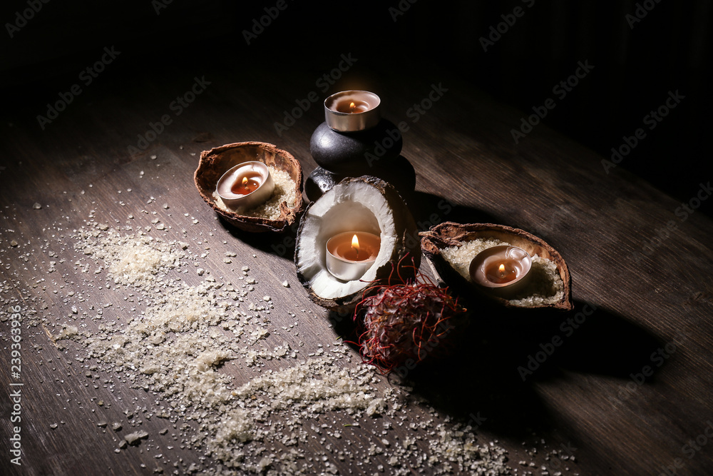 Beautiful spa composition with burning candles and coconut on wooden table Beautiful spa composition with burning candles and coconut on wooden table