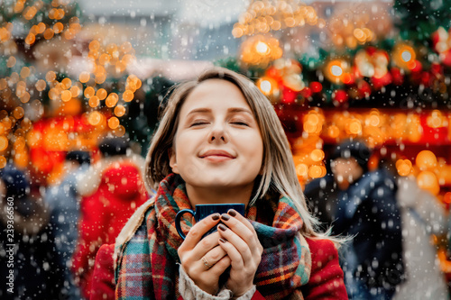 Bild auf Leinwand Beautiful adult girl with cup of hot drink at Christmas fair in Dresden, Germany