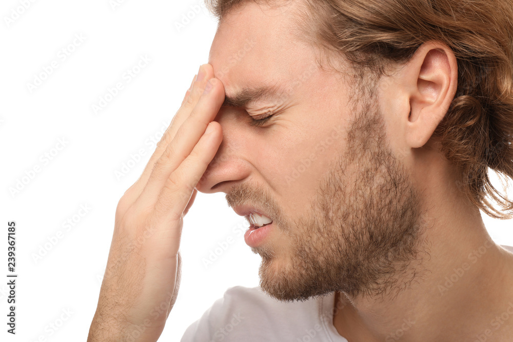 Obraz premium Young man suffering from headache on white background, closeup