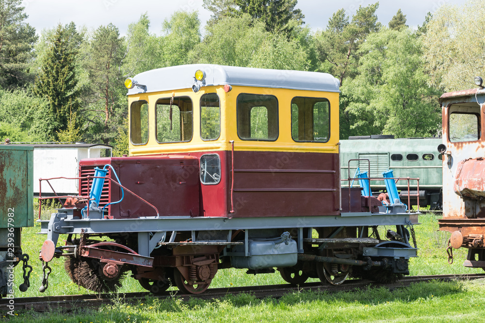 Old train and locomotive. Railroad tracks stretches and green grass and trees. Railway road environment background.