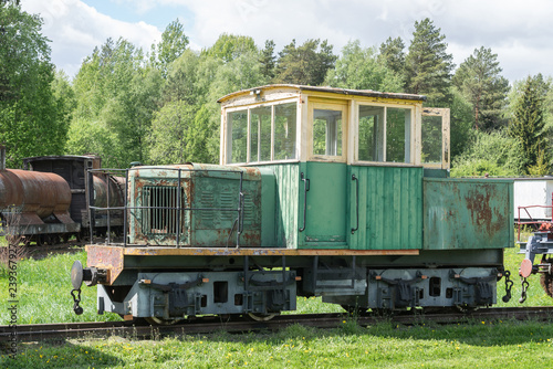Old train and locomotive. Railroad tracks stretches and green grass and trees. Railway road environment background.