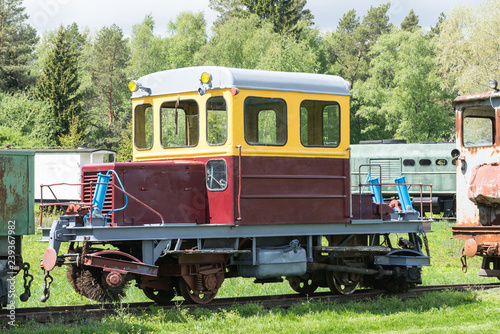 Old train and locomotive. Railroad tracks stretches and green grass and trees. Railway road environment background.