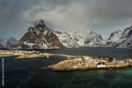 View of beautiful Sacrisoya village in winter time with montains in background with light of sunrise. Lofoten  Norway.