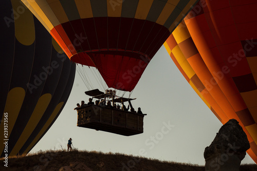 Silhouette of a man taking pictures of a balloon at sunrise