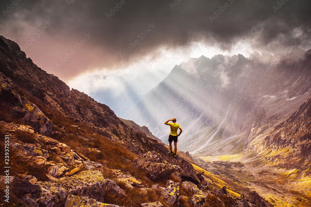 Man standing over the valley in mountains. Beautiful light, inspirational photo