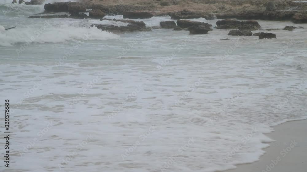waves of mediterranean sea splashing about stones and sand during a storm waves of mediterranean sea splashing about stones and sand during a storm