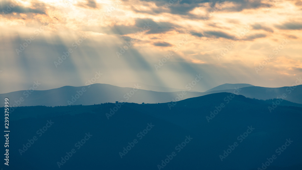 Beautiful sunset rays falling on top of a valley in Buila Vanturarita mountains, Romania