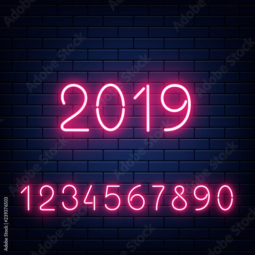Vector illustration set of glowing neon numbers and 2019 New Year sign on dark brick wall background in realistic style. Pink shining numerals for congratulation poster.