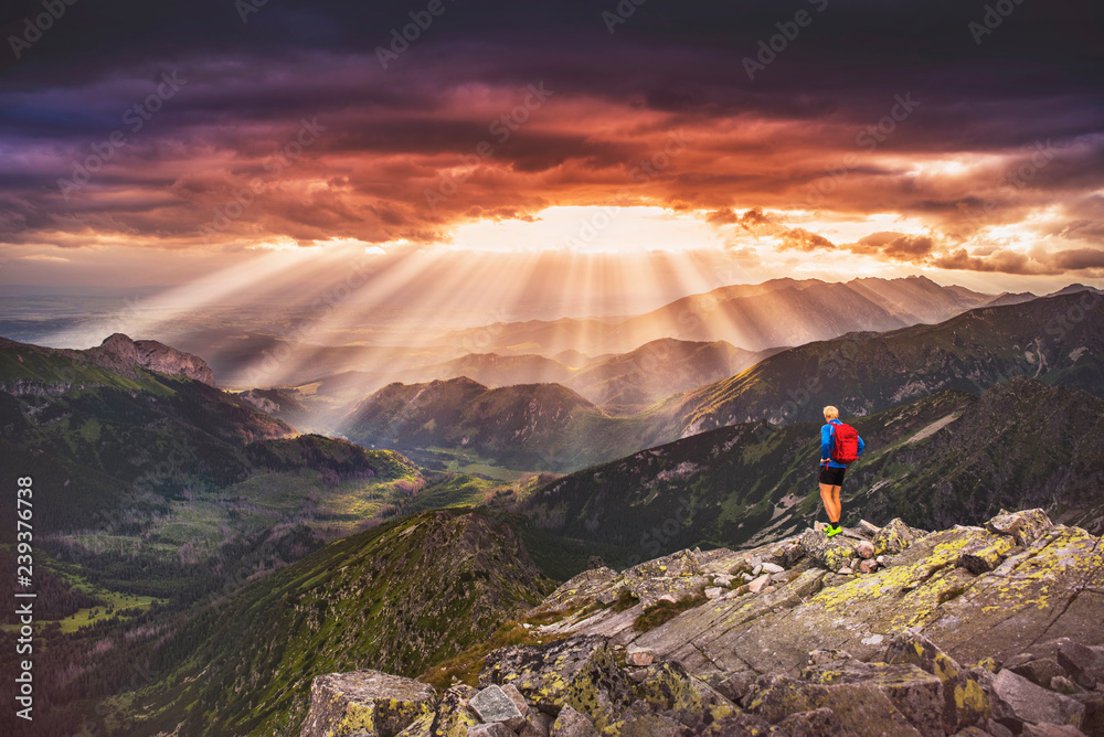 Tourist and rays of the sun in mountains. hiking, adventure photo