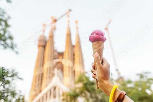 Photography Young woman tourist eating ice-cream in front of the famous Sagrada Familia land