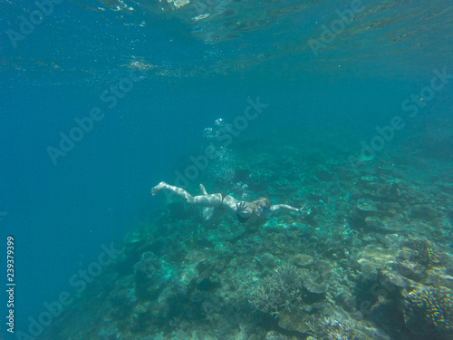 Young girl diving in a blue clean water