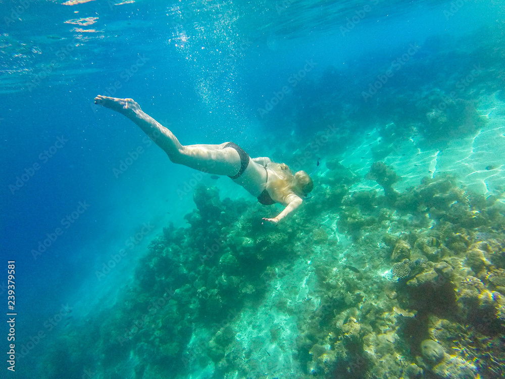 Young girl diving in a blue clean water